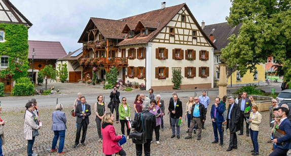 Bild zeigt Dorfplatz mit Menschen