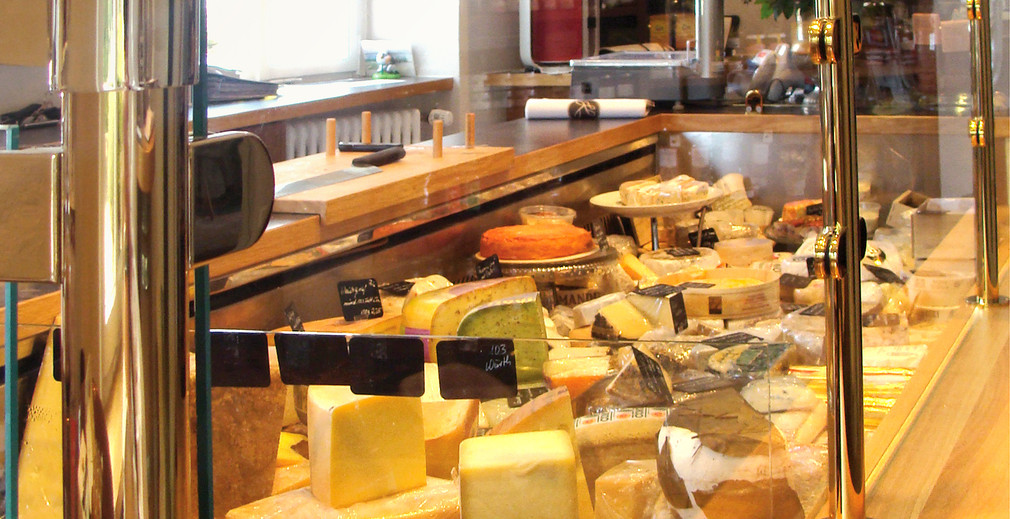 Im Cafe und Feinkostgeschäft Käseschmiede werden Käserohlinge von Mitarbeiterinnen zu feinem Käse veredelt