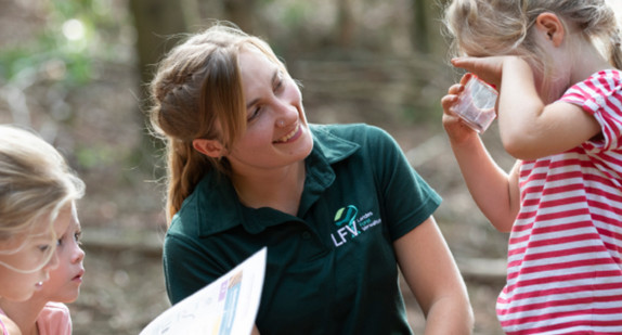 Frau mit drei Kindern im Wald