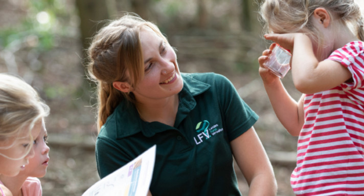 Frau mit drei Kindern im Wald