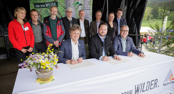Minister Alexander Bonde (Mitte), Dr. Frank Mentrup, Oberbürgermeister der Stadt Karlsruhe, (links) und Dr. Klaus Michael Rückert, Vorsitzender des Nationalpark-Rats, (rechts) unterzeichnen die Patenschaftsurkunde (Foto: Jan Potente).