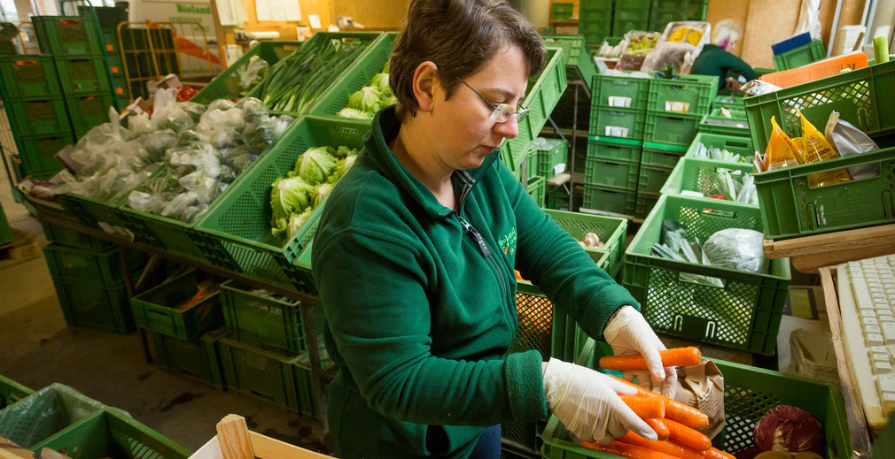 Lieferantin stellt Obst- und Gemüsekiste zusammen. Foto: Jan Potente/MLR